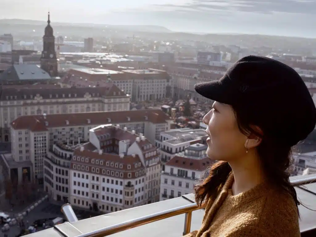 Frau mit Mütze, die über die Dresdner Altstadt schaut