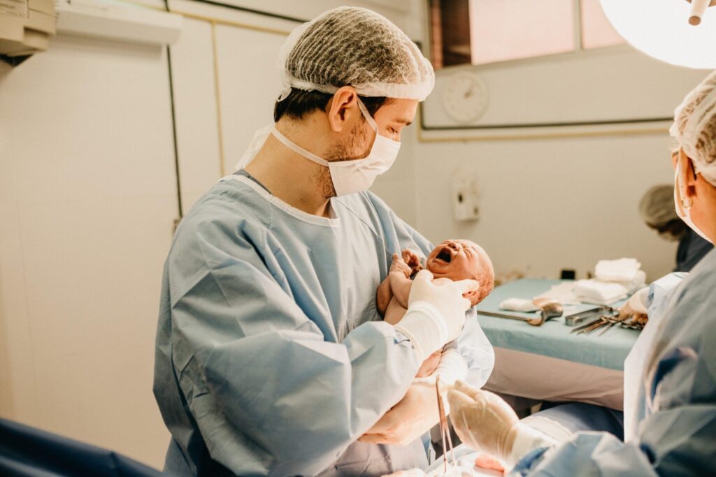 Neugeborenes in den Armen eines Arztes im Krankenhaus