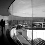 Menschen im Gebäude mit Glassfassade